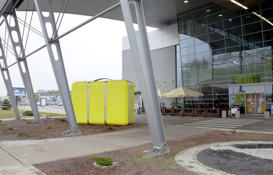 Żółta walizka przed poznańskim lotniskiem