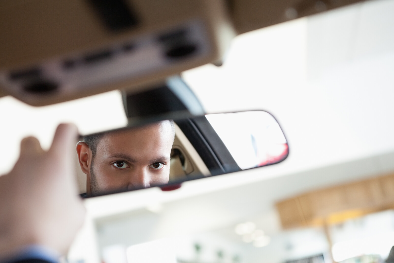 Водитель смотрит в зеркало. Человек машина на зеркало. В зеркале машины мужчина. Человек смотрит в зеркало машины.