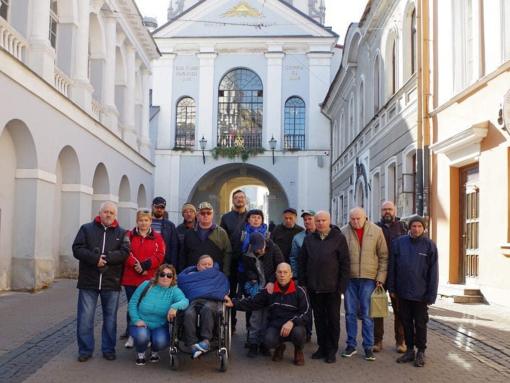 Fot. fundacjabonifraterska.org / Opiekunowie wraz z pacjentami przed Ostrą Bramą w Wilnie